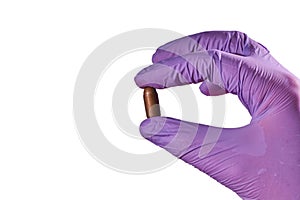 The hand of a man in a glove holding a bullet shell