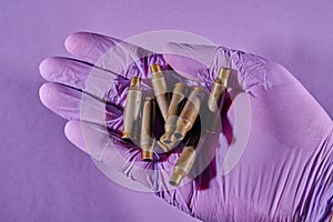 The hand of a man in a glove holding a bullet shell