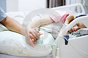 Hand of man hold hands with woman on the hospital bed