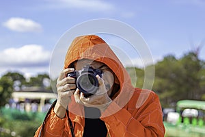 Hand man holding the camera Taking pictures background tree and sky