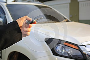 Hand of man holding car remote control pointing to car door open, Car security lock system concept