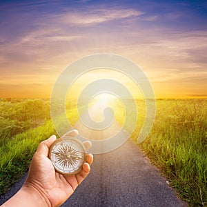 Hand man holding compass navigator on road way