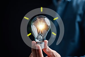 Hand man holding illuminated lightbulb, idea, innovation and inspiration with glowing virtual brain, smart intelligent creativity