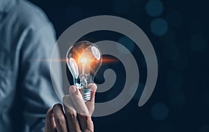 Hand man holding illuminated lightbulb, idea, innovation and inspiration with glowing virtual brain, smart intelligent creativity
