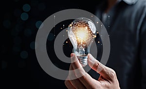 Hand man holding illuminated lightbulb, idea, innovation and inspiration with glowing virtual brain, smart intelligent creativity