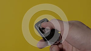 Hand of man holding and pressing car remote key