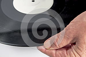 The hand of a man holding a vinyl record