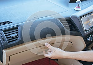 Hand man open glove compartment in car