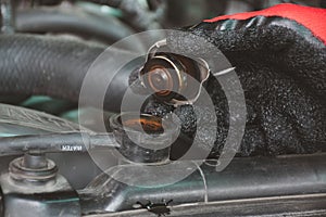 Hand a man opening the Radiator cap of engine for check level of water Car radiator