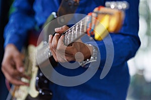 Hand of man playing on electric guitar. An unrecognizable musician guitar player performing music with an instrument