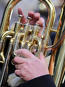 hand of man plays the trombone in the brass band