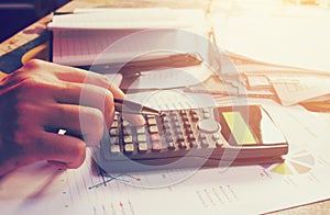 Hand man pressing on calculator with calculation about tax annual at home office.