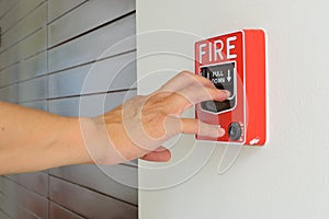 The hand of man is pulling fire alarm