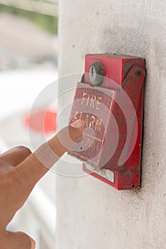 The hand of man is pulling fire alarm