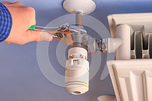 Hand of a man, repairman, installation radiator valve closeup