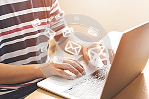 Hand of man sending message and laptop with e-mail icon