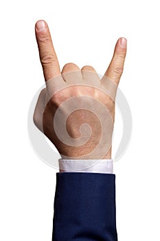 The hand of a man in a suit shows a goat gesture on a white background. Isolate