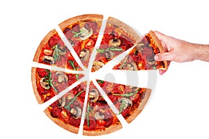 Hand of a man take a slice of pizza with spicy salami, arugula, tomatoes, mushrooms and texas spice mix, isolated on white