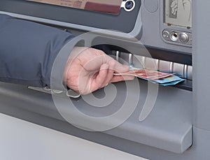 Hand of man to withdraw money from an ATM