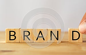 Hand man try to complete the Brand word on wooden cube, Brand concept photo