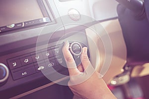 Hand of man turning on car air conditioning system,Button on dashboard in car