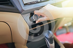 Hand of man turning on car air conditioning system,Button on dashboard in car
