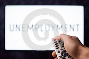 Hand of a man turning off tv with unemployment inscription