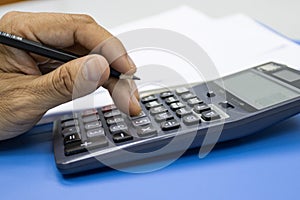 Hand of man use use calculators with documents of income, expenses, concept of life at work
