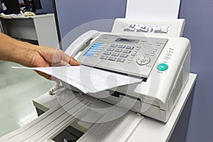 Hand man are using a fax machine in the office photo