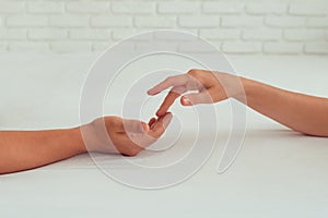 The hand of a man and a woman caresses each other while lying in bed