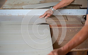 Hand of man working cutting boards by machine