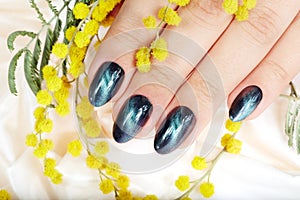 Hand with manicured nails with cat eye design