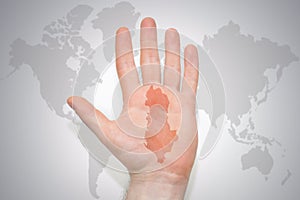 Hand with map of albania on the gray world map background