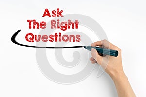 Hand with marker writing - Ask The Right Questions concept. White paper background
