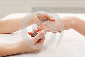 Hand massage at spa salon on white towel photo