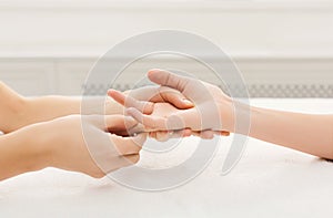 Hand massage at spa salon on white towel