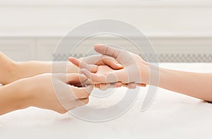 Hand massage at spa salon on white towel photo