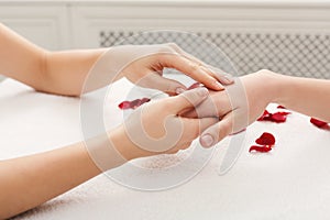 Hand massage at spa salon on white towel photo