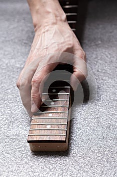 Hand of a master on the fretboard of a guitar.