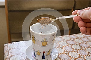 Hand measuring a spoon full of instant coffee