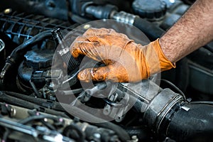 Hand of a mechanic on a car engine