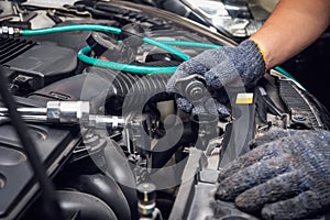 Hand of Mechanic check water in car radiator and add water antIfreeze coolant fluid to car radiator at garage , service and