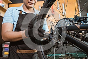 hand of a mechanic wearing gloves setting bicycle spoke