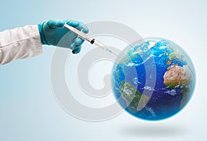 Hand with a medical glove giving a vaccine injection to planet Earth
