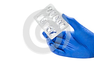 Hand with medical glove holding empty pill blister pack