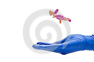 Hand with medical glove holding pill