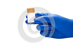 Hand with medical glove holding pill bottle