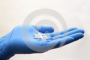 Hand in medical glove takes pill - choice medicine, coronavirus, covid19