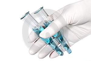 Hand in a medical latex glove holds two test tubes with a blue liquid