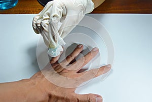 Hand in medical rubber glove cleaning to wound